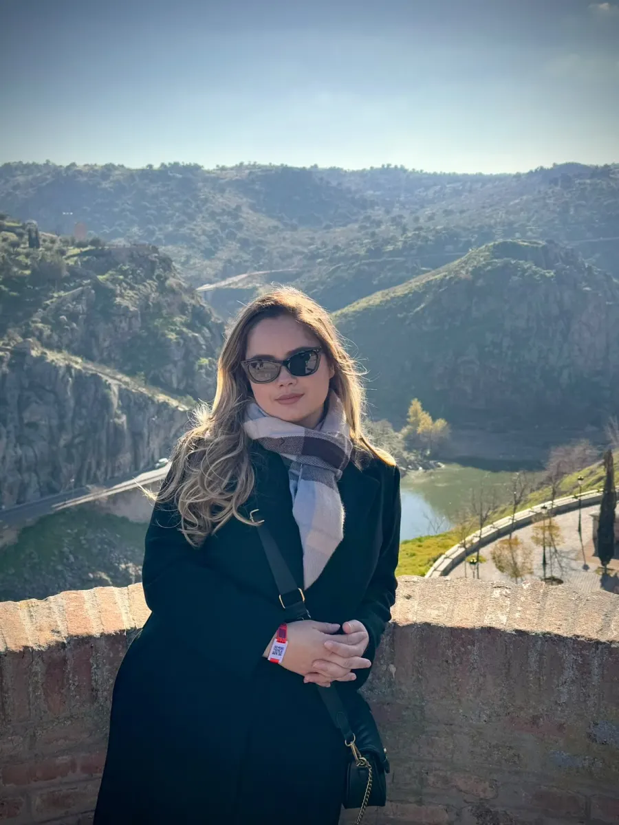 Karol num mirante, de cachecol e óculos escuros